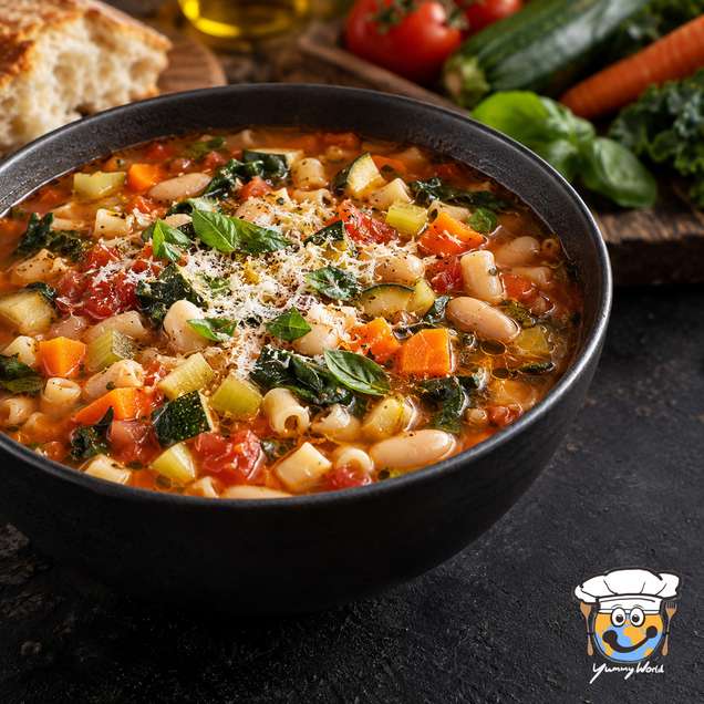 Minestrone soup with white beans, pasta and colorful vegetables, topped with grated cheese and herbs.